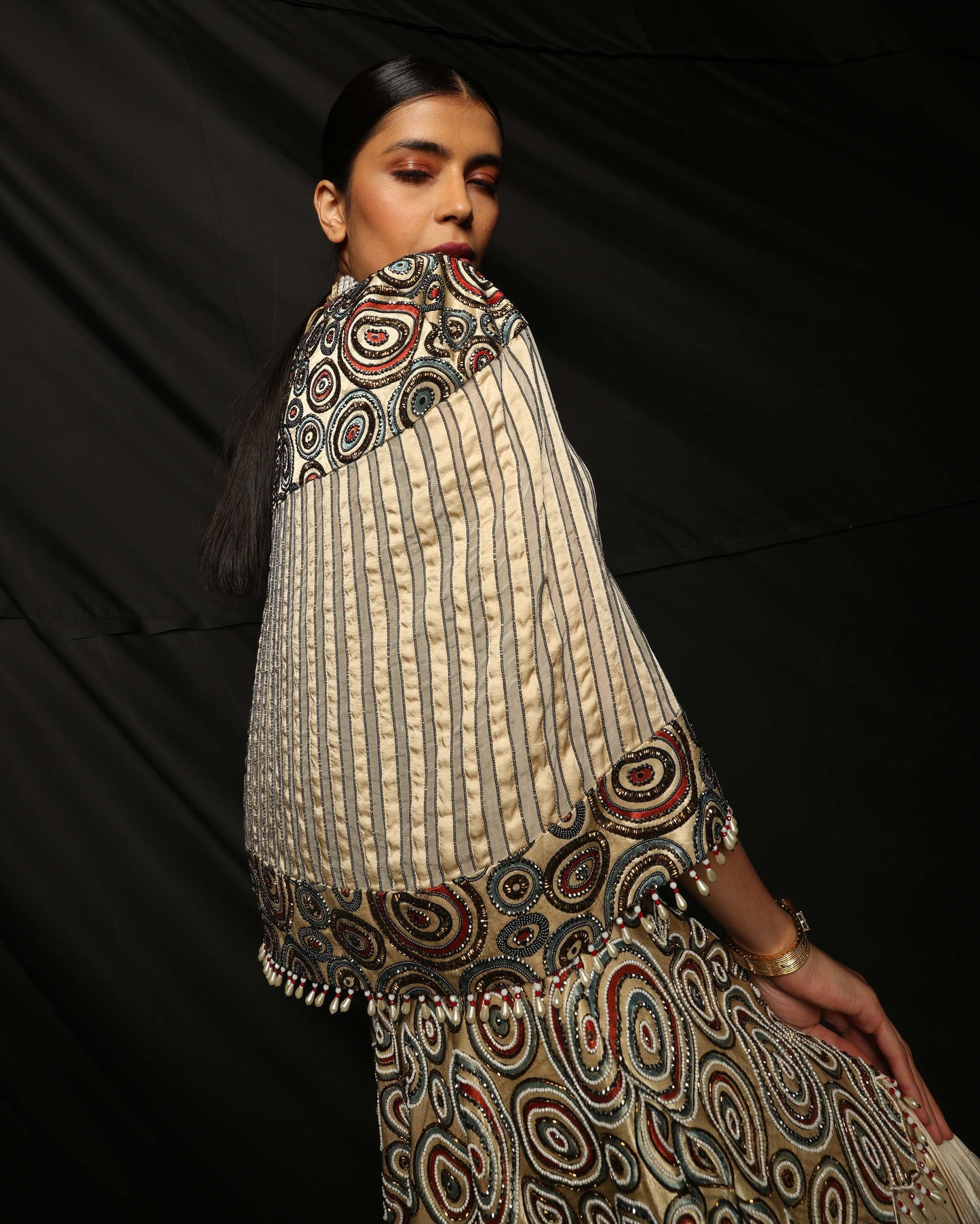 Cream Ajrakh embellished blouse and cape with layered lehenga.