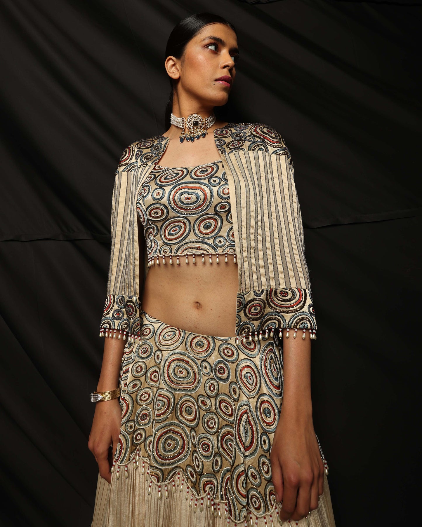 Cream Ajrakh embellished blouse and cape with layered lehenga.