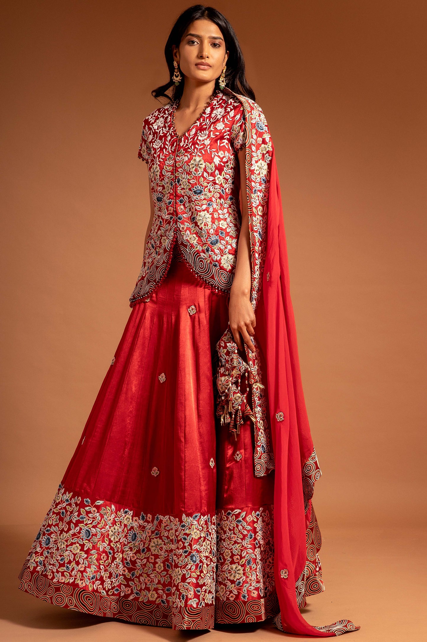 Red Lehenga and koti jacket with cape dupatta.