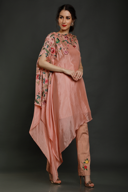 "Elegant peach crepe one-sided drape kaftan with thread, pearls & cutdana detailing, paired with stretch lycra pants - A stylish fusion outfit!"