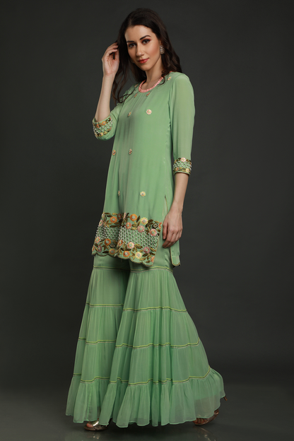 "Stunning mint green crepe kurta with intricate threadwork, pearl beads & cutdana, paired with layered garara & shaded dupatta - A mesmerizing ensemble!"