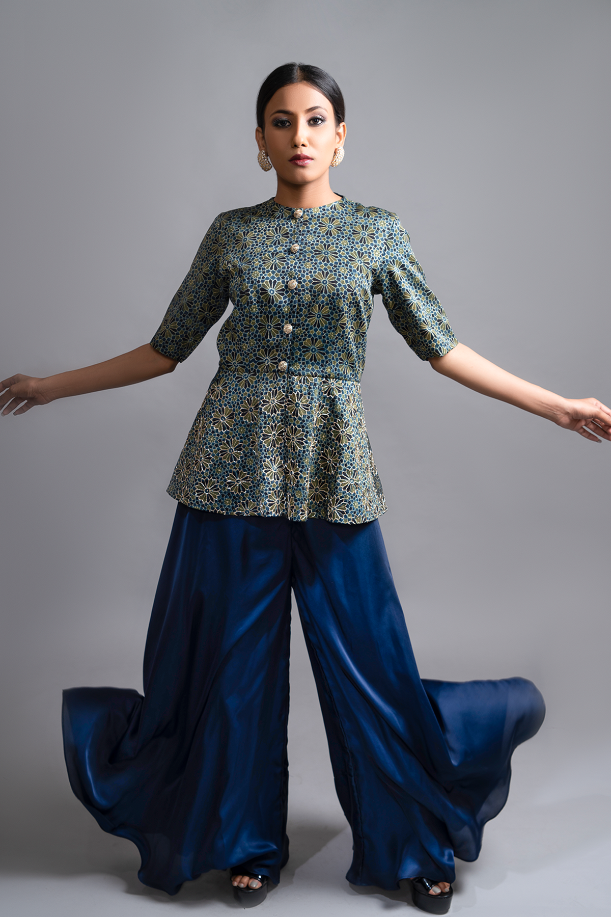 "Stunning Ajrakh Peplum Top in Pure Modal Silk, adorned with Intricate Nakshi and Zardosi work, beautifully paired with Blue Flared Pants in Pure Satin Crepe."