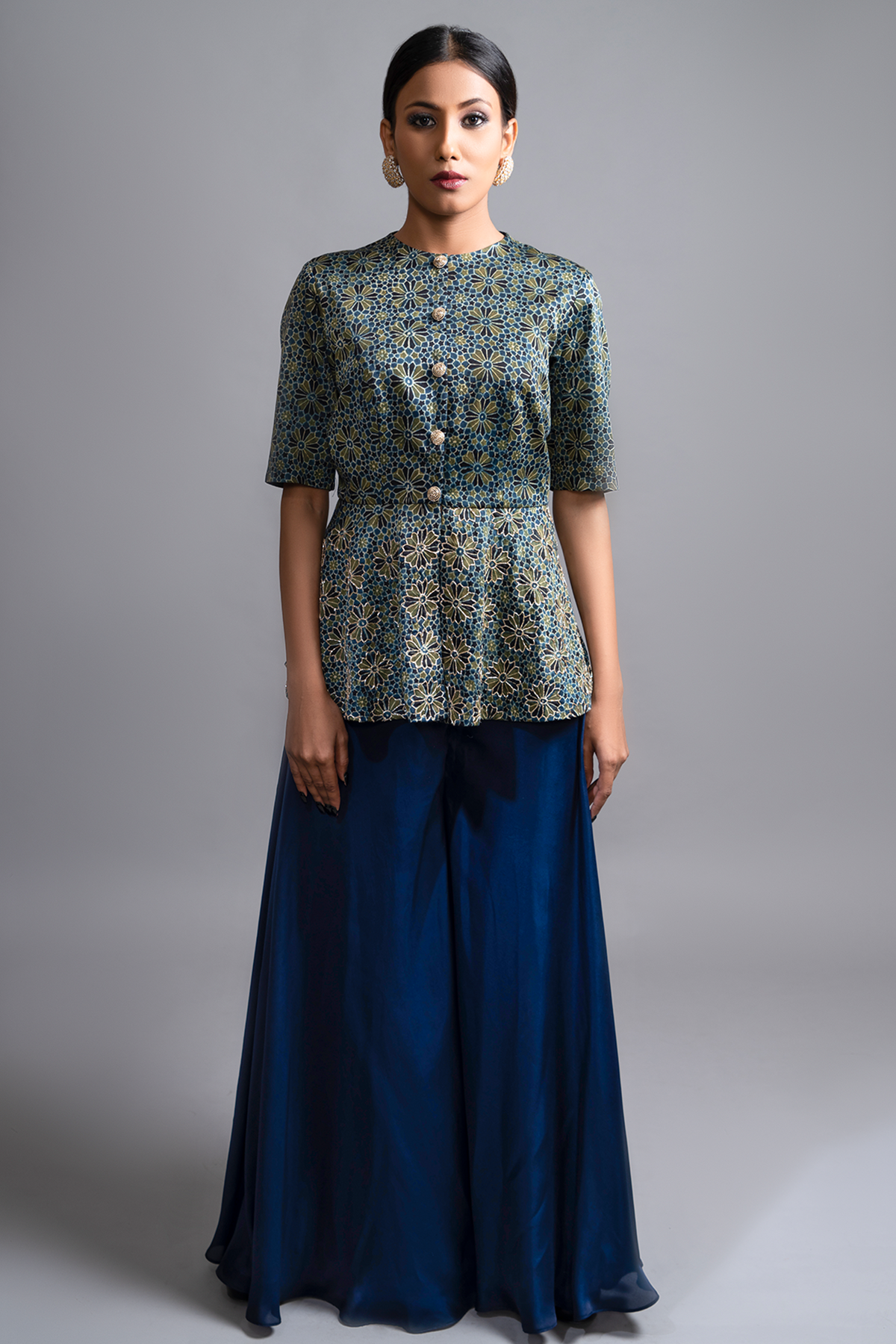 "Stunning Ajrakh Peplum Top in Pure Modal Silk, adorned with Intricate Nakshi and Zardosi work, beautifully paired with Blue Flared Pants in Pure Satin Crepe."