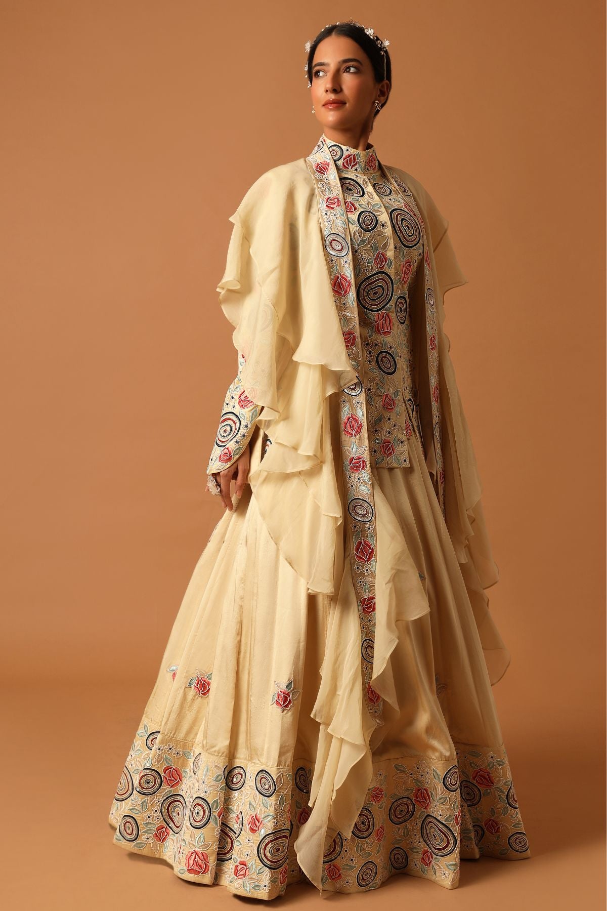 "Step into exquisite elegance with a fully embroidered short kurta, bordered lehenga, and a ruffled organza dupatta. Explore timeless beauty!"