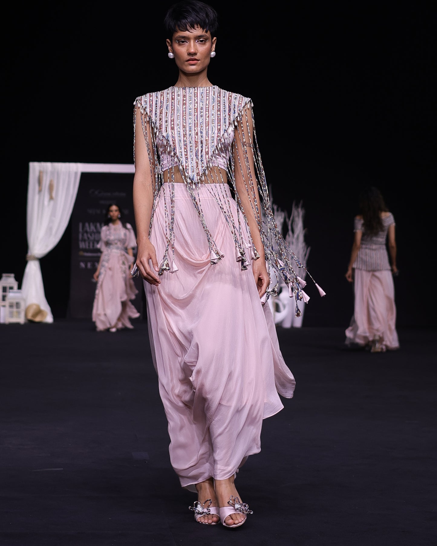 Peachy Pink ajrakh stripwork jacket paired up with Peachy pink bralette and drape dhoti skirt