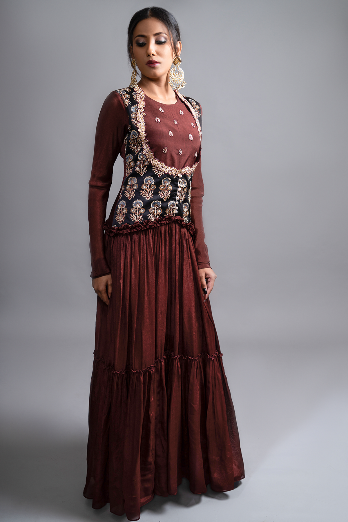 "Mesmerizing Maroon Pleated Gown paired with a Waist Koti Style Ajrak Jacket in Mashru Silk, adorned with intricate and beautiful work. Embrace the allure!"