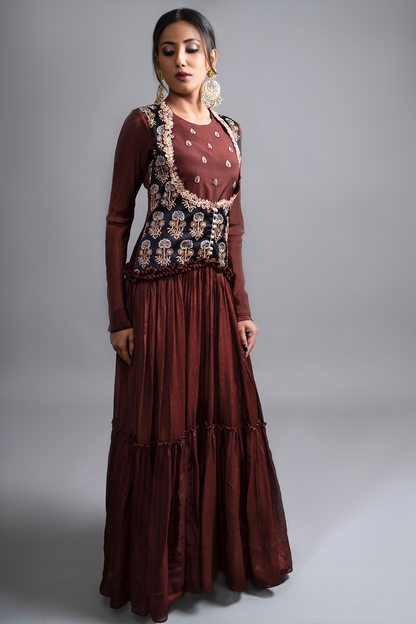 "Mesmerizing Maroon Pleated Gown paired with a Waist Koti Style Ajrak Jacket in Mashru Silk, adorned with intricate and beautiful work. Embrace the allure!"