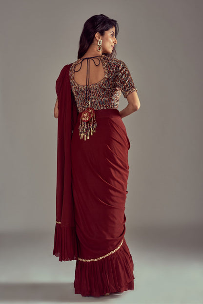 Exquisite Maroon Ruffled Saree paired with an Ajrakh Printed Blouse featuring Intricate Embroidery in Mashru Silk, complemented by a Fully Handcrafted Waistband