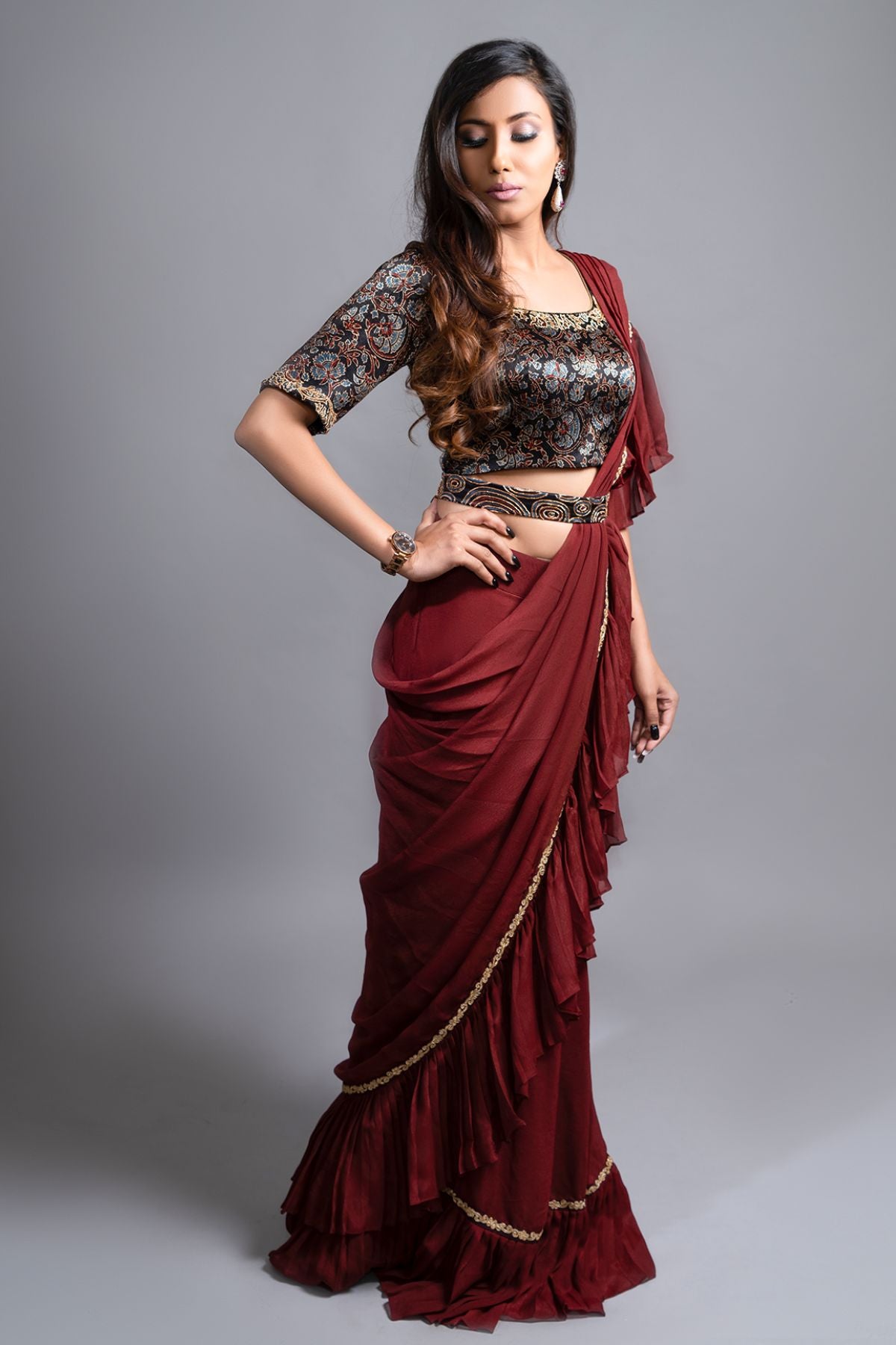 "Graceful Maroon Ruffled Saree paired with an Ajrakh Printed Blouse, featuring Intricate Embroidery in Mashru Silk. Fully Handcrafted Ajrakh Waistbelt."