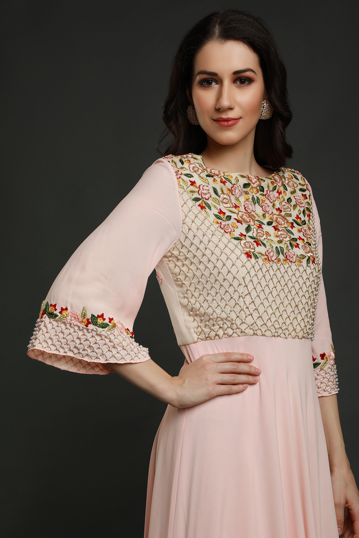 Step into elegance with a Light Peach crepe flared tunic dress. Hand-embroidered yoke, pleated panel, and exquisite detailing for a timeless look.