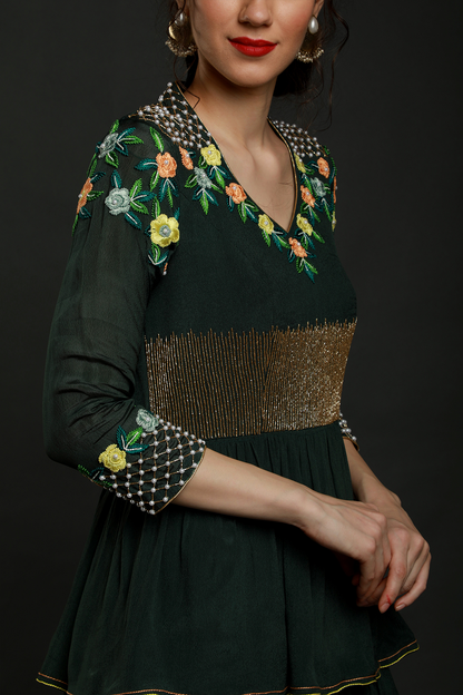 Elegance meets allure in our Bottle Green Layered Ankle Length Dress. Thread work, cutdana, and pearl embellishments on yoke and sleeves add enchanting charm.